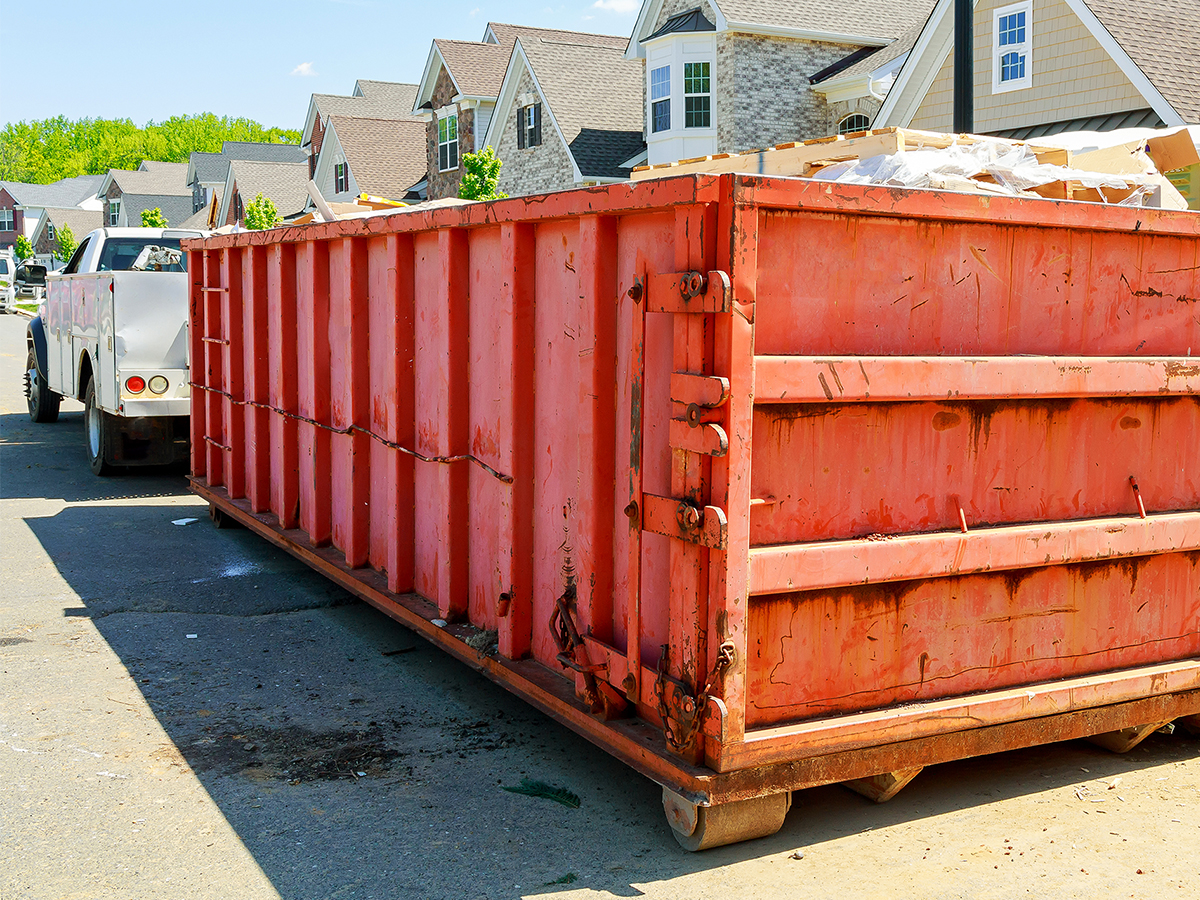Dumpster attached to a truck in a neighborhood